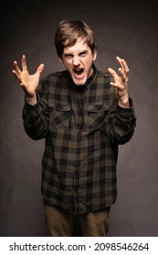 Young Handsome Tall Slim White Man With Brown Hair Looking Really Angry With Flannel Shirt On Grey Background