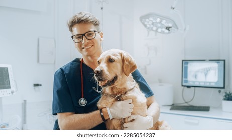 Young Handsome Veterinarian Petting a Noble Golden Retriever Dog. Healthy Pet on a Check Up Visit in Modern Veterinary Clinic with a Professional Caring Doctor - Powered by Shutterstock