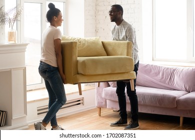 Young Happy African American Couple Moving And Carry Table. Attractive Family Of Diverse Woman And Man Relocation Furniture In New Home. Husband And Wife Perform Permutation.