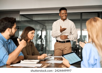 Young happy African American male executive company leader discussing project management planning strategy working with diverse busy colleagues company team at office corporate board group meeting. - Powered by Shutterstock