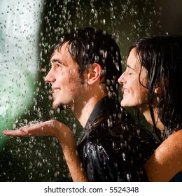 Young Happy Amorous Couple Hugging Under A Rain