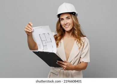 Young happy architect designer employee white woman wear pastel clothes hardhat hold read tablet document isolated on plain light grey background studio portrait. People work on architecture project - Powered by Shutterstock