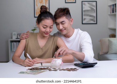 Young Happy Asian Couple Saving Money To Buy A House. Man And Women Couple Saving Money For Family And Home.