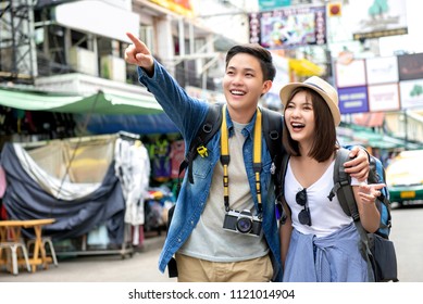 Young happy Asian couple tourist backpackers enjoy traveling in Khao San road during vacations in Bangkok, Thailand - Powered by Shutterstock