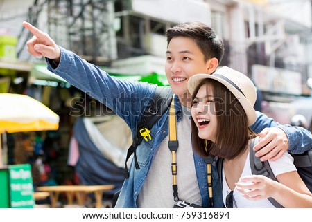 Young happy Asian couple tourist backpackers enjoy visiting Khao San road on summer holiday traveling in Bangkok, Thailand