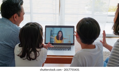 Young Happy Asian Family Online Video Call With Friend Or Relative Cousin, Using Laptop Computer At Home. Internet Information Technology, Social Distancing Or Coronavirus New Normal Lifestyle Concept