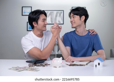 Young Happy Asian Gay Couple Saving Money To Buy A House. LGBT Men Couple Saving Money For Family And Home.