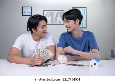 Young Happy Asian Gay Couple Saving Money To Buy A House. LGBT Men Couple Saving Money For Family And Home.