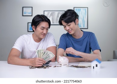 Young Happy Asian Gay Couple Saving Money To Buy A House. LGBT Men Couple Saving Money For Family And Home.