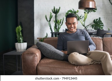 Young Happy Asian Man Using The Laptop At Home.