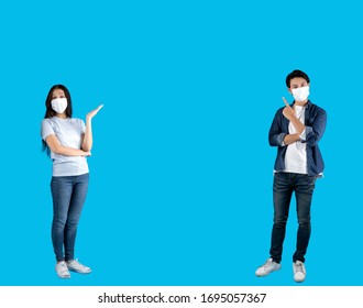 Joven y feliz asiático apuntando a copiar el espacio usando máscara higiénica para prevenir la infección por el virus corona.