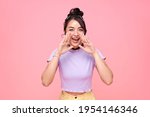 Young happy asian teen woman shout story or making announcement isolated on pink background.