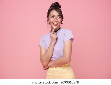 Young Happy Asian Teen Woman Thinking Something Isolated On Pink Background.	