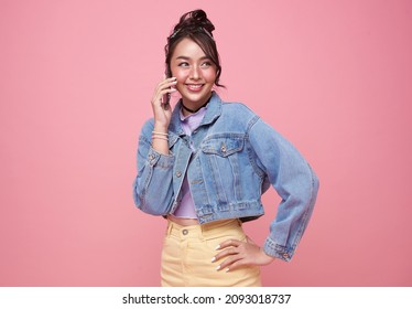 Young Happy Asian Teen Woman Talking Smart Phone Isolated Over Pink Background.	