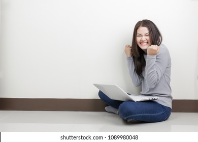 Young Happy Asian Woman With Laptop Sitting In The Room. Winning In Game.