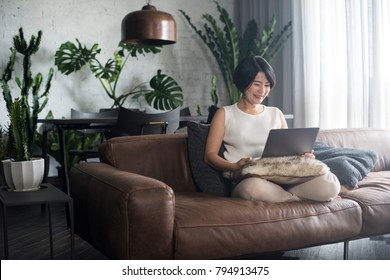 Young Happy Asian Woman Using The Computer At Home.