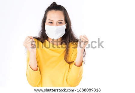 Young happy Asian woman wearing hygienic mask to prevent infection corona virus Air pollution pm2.5 she wearing a yellow sweater shoot in shot isolated on white background