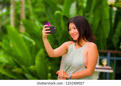young happy and attractive Asian Korean woman taking selfie self portrait with mobile phone at tropical island posing cheerful and relaxed exploring jungle and nature enjoying holidays travel   - Shutterstock ID 1252309027