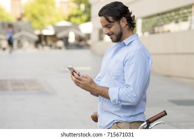 young happy attractive hispanic man in casual trendy clothes smiling cheerful using mobile phone on vintage cool retro bicycle in modern stylish lifestyle urban style concept 