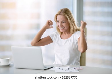 Young happy attractive woman at modern office desk, with laptop feeling great things on career horizon, saying yes to new adventures, cheerful good morning news, working toward success and reached it 