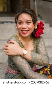 young happy and beautiful Asian woman wearing traditional Balinese kebaya dress - Indonesian girl in Bali clothes walking on street during holidays travel in Europe