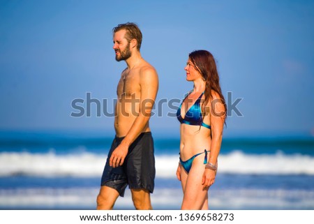 young happy and beautiful couple enjoying Summer holidays travel or honeymoon trip together in tropical paradise beach having fun relaxed and playful on the sea smiling cheerful