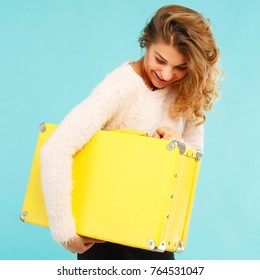 Young Happy Beautiful Woman Holding Yellow Suitcase Over Blue Background