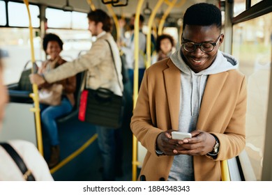 Young Happy Black Man Text Messaging On Smart Phone While Traveling By Bus. 