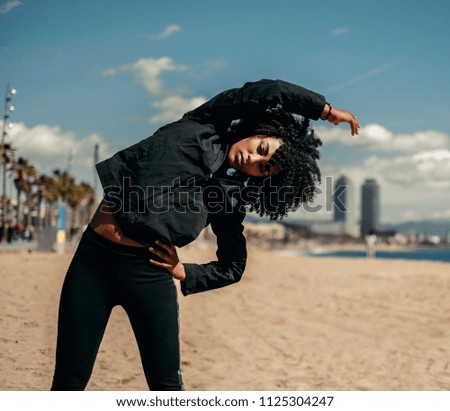 Young happy black woman doing workout outdoors