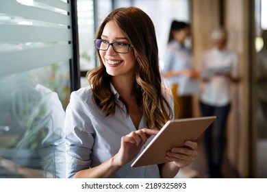 Young happy business woman working with tablet in corporate office