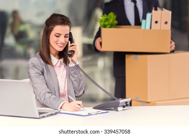 Young Happy Businessman And A Business Woman With Boxes For Moving Into A New Office