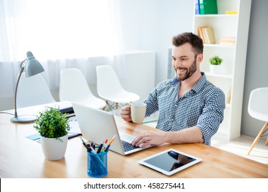 Young  Happy Businessman  Drinking Coffee While Working On Laptop