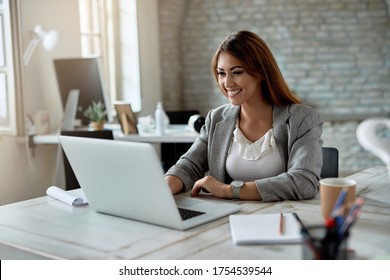 Young Happy Businesswoman Using Computer While Working In The Office. 