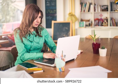 Young happy businesswoman working on laptop in the office
