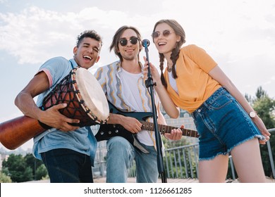 Young Happy Buskers Singing By Microphone At City Street