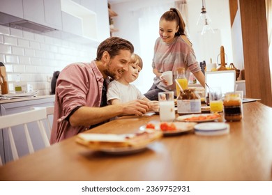 Young happy caucasian family having breakfast together in the kitchen - Powered by Shutterstock