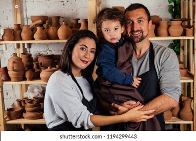 Young Happy Caucasian Family With Son Working On Potter Shop .beautiful Mother With Dad And Little Boy Making Ceramic Pot On The Pottery Art Class Workshop.love , Care And Tenderness