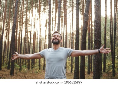 Young happy Caucasian male in the forest. He spread his arms and closed his eyes. Wellness concept and holistic rest - Shutterstock ID 1966515997