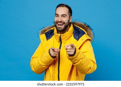 Young happy caucasian man 20s he wearing yellow down jacket point index finger camera on you say do it motivate isolated on plain blue color background studio portrait. People winter lifestyle concept - Powered by Shutterstock