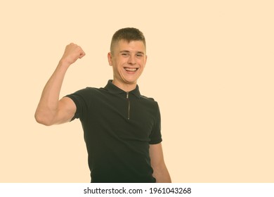 Young happy Caucasian man smiling and flexing arm