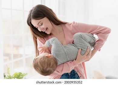 Young happy caucasian mother playing with her little small kid child. Nanny childminder lulling toddler newborn baby, putting to sleep. Motherhood adoption and IVF concept