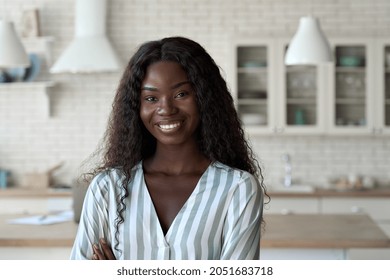 Young happy cheerful gorgeous African American black girl student in smart casual clothing with perfect smile posing indoors at modern kitchen home office looking at camera. Headshot portrait. - Powered by Shutterstock
