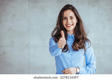 Young happy cheerful woman showing thumb up. Positive caucasian young girl woman showing thumb up looking at camera, checking for good quality recommendation isolated in grey background.Great job! - Shutterstock ID 2278114397