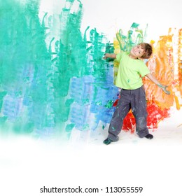 Young Happy Child Boy Painting White Wall With Colours