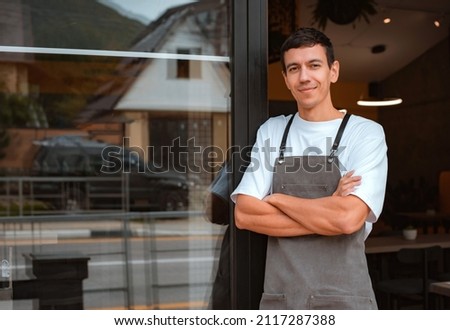Young happy confident young man cafe or coffee shop owner being proud of his small business