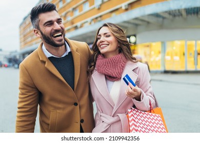 Young Happy Couple After Shopping Holding A Credit Card