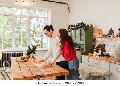 Young happy couple backing cooking at christmas winter holidays on the kitchen indoors ate home light image. Man woman relationships and family love - Powered by Shutterstock