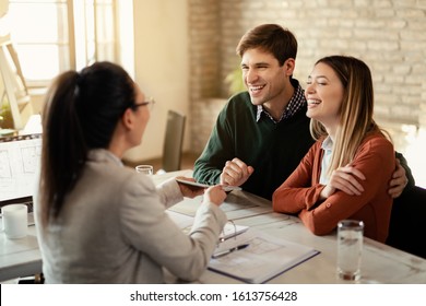 Young Happy Couple Communicating With Financial Advisor Who Is Using Digital Tablet During A Meeting. 