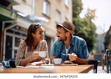 Young happy couple communicating while sitting in sidewalk cafe. - Powered by Shutterstock