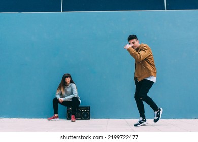 Young Happy Couple Dancing On The Street With A Vintage Radio Cassette Stereo 
